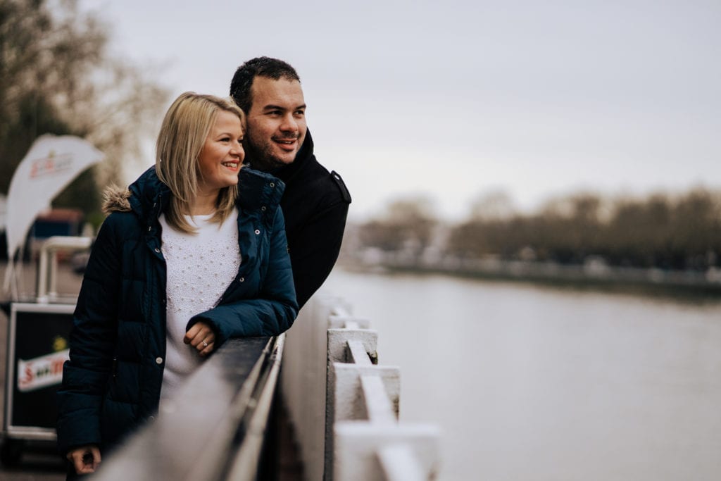 Loving pre wed couple pictured overlooking river taken during their pre wedding engagement shoot at Fulham FC
