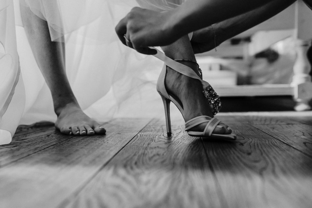 bride putting her wedding shoes