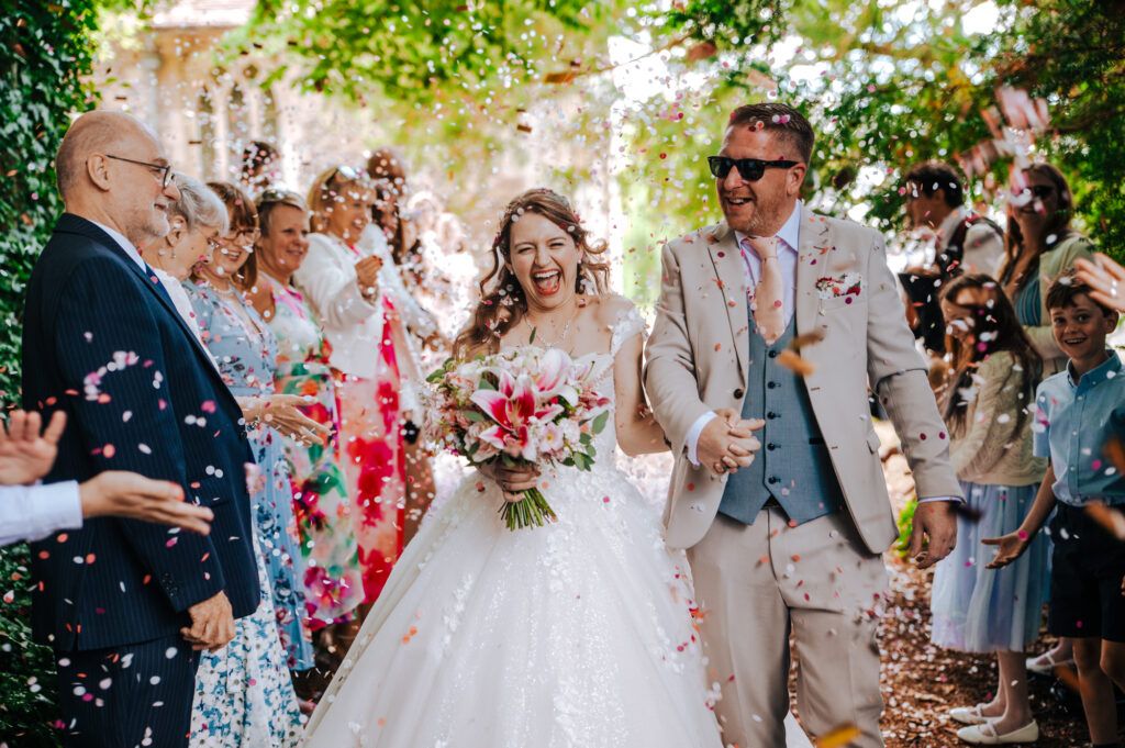 Couple walking through confetti after celebrating their wedding ceremony
