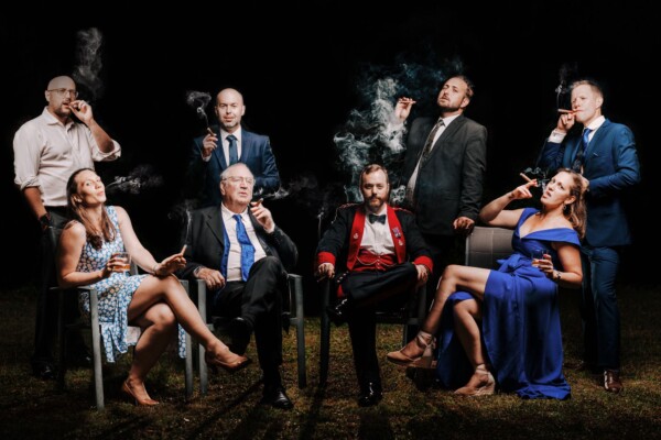 Dramatic nighttime cigar wedding group portrait with cinematic lighting by Alex Buckland Photography