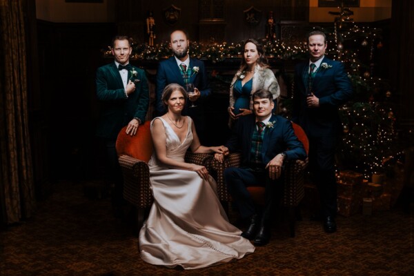 Editorial wedding party portrait with warm indoor lighting and classic styling