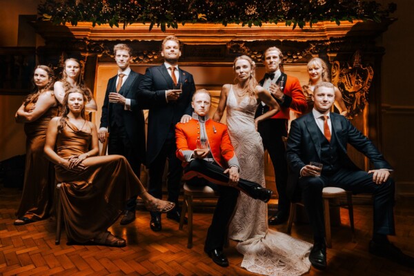 Creative wedding group shot at night with dramatic lighting and military dress uniforms