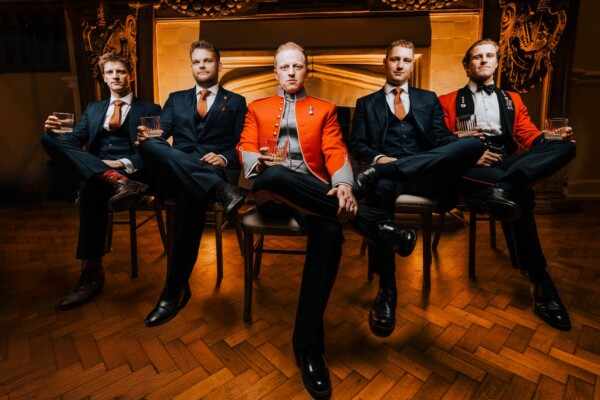 Editorial portrait of groom and groomsmen in military dress uniform captured indoors